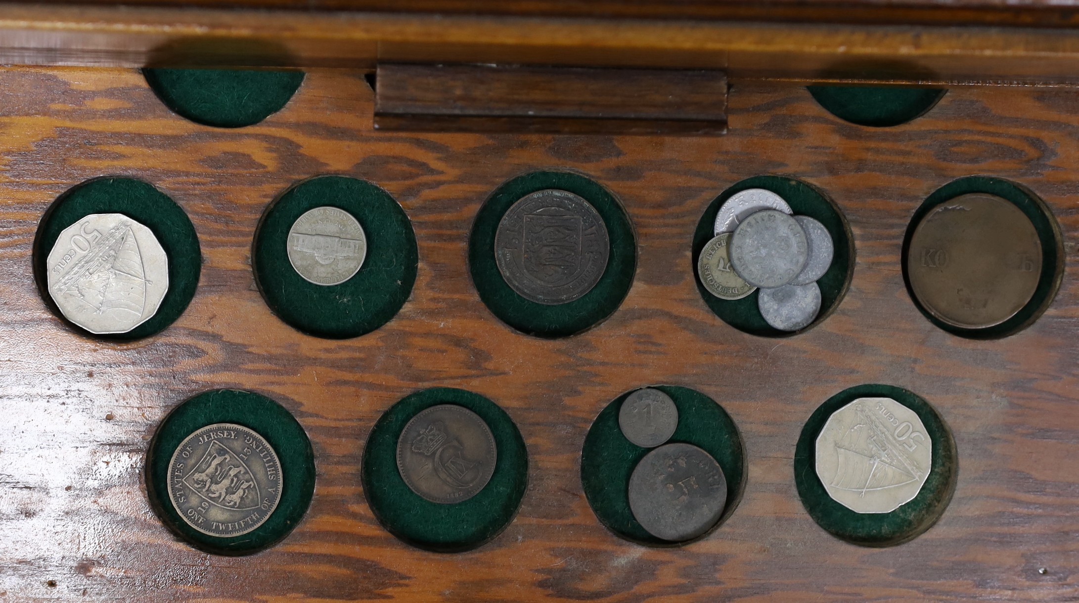 A collection of mixed coinage in a collectors cabinet, 27cm tall